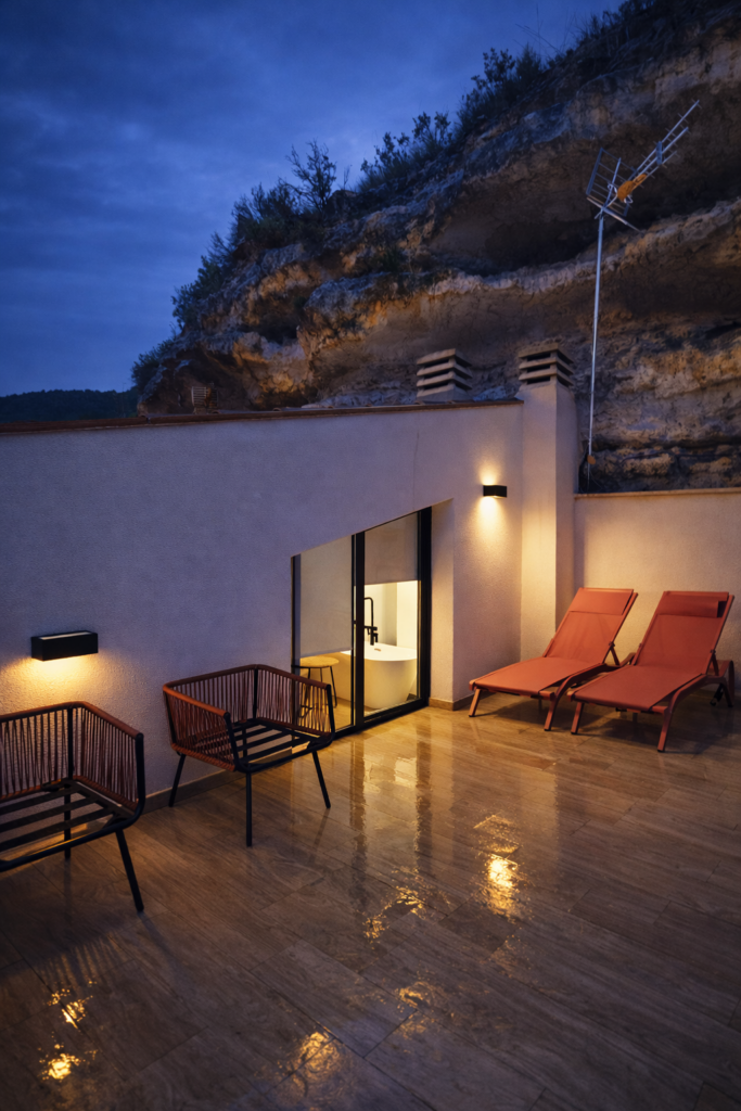 Terraza privada con tumbonas y zona de descanso de Kalea Suite