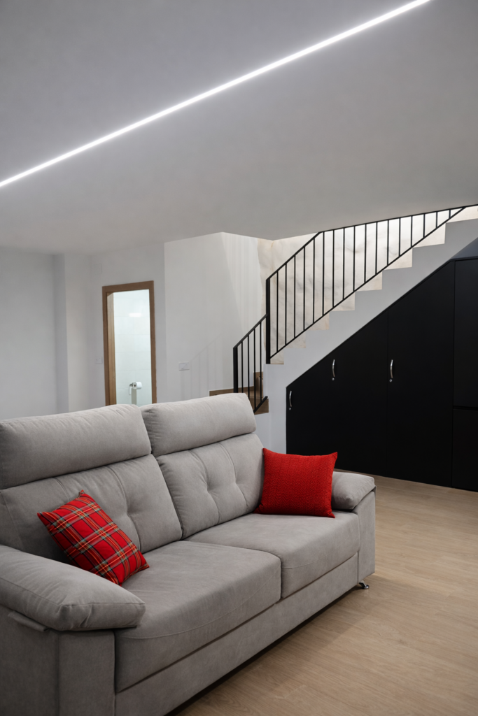Salón con sofás y escalera interior en casa rural Kalea Elysivm